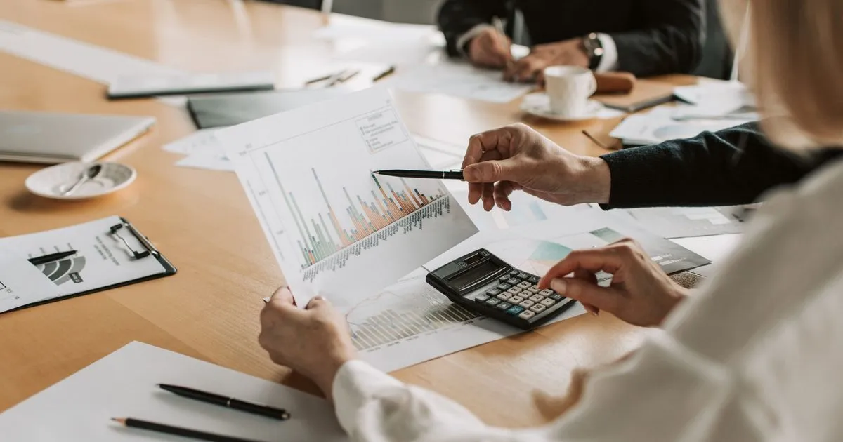 Board members reviewing financial charts with a calculator