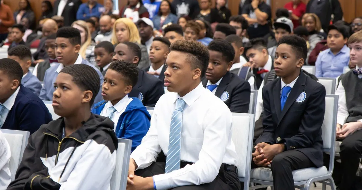 Students and families listening at a school assembly