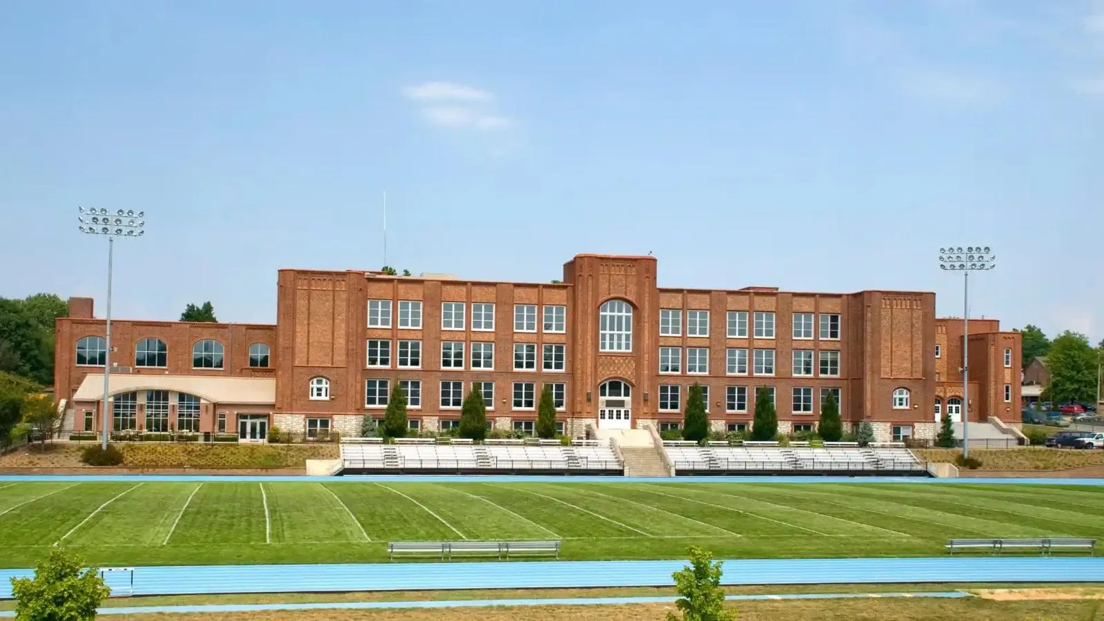 Brick school building behind a sports field