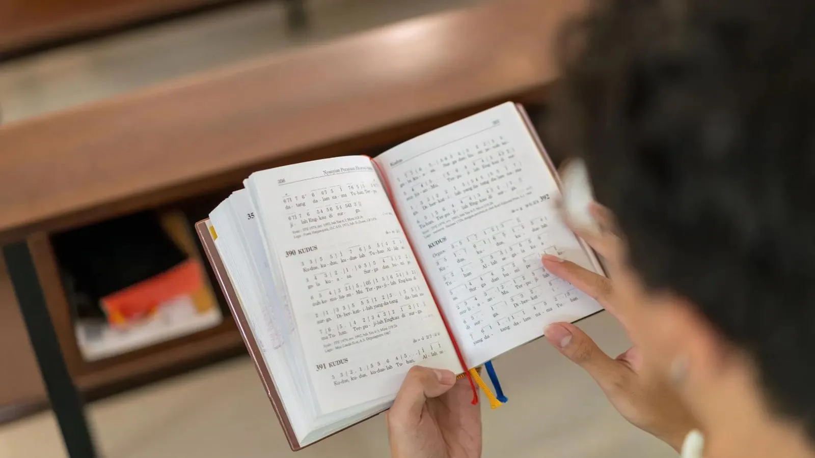 Person reading from an open hymnal