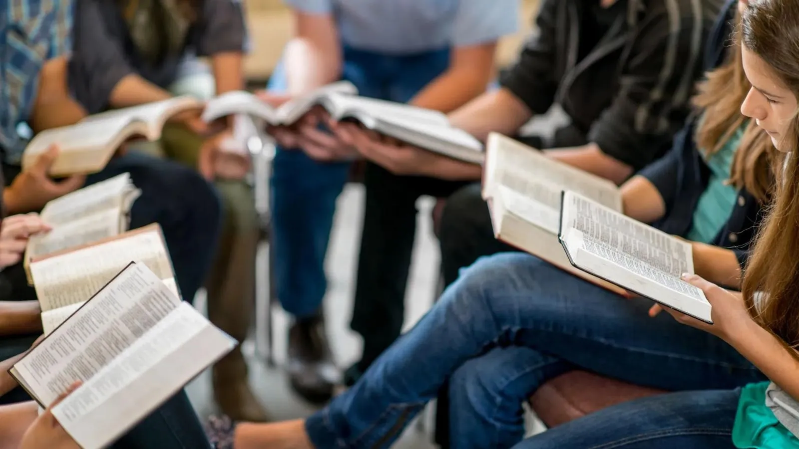 Group of people reading open Bibles together